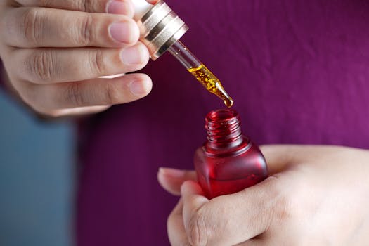 Detailed image of hands using a dropper with a red glass bottle. Perfect for skincare and beauty themes.