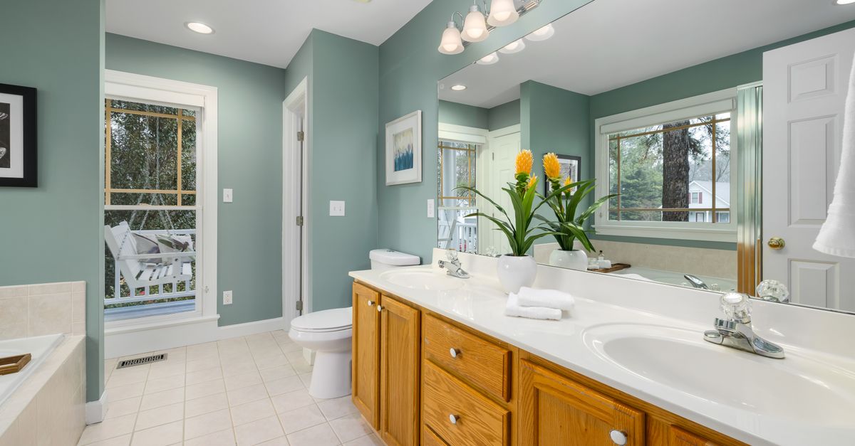 Spacious bathroom featuring a dual sink vanity, large mirrors, and elegant interior design.