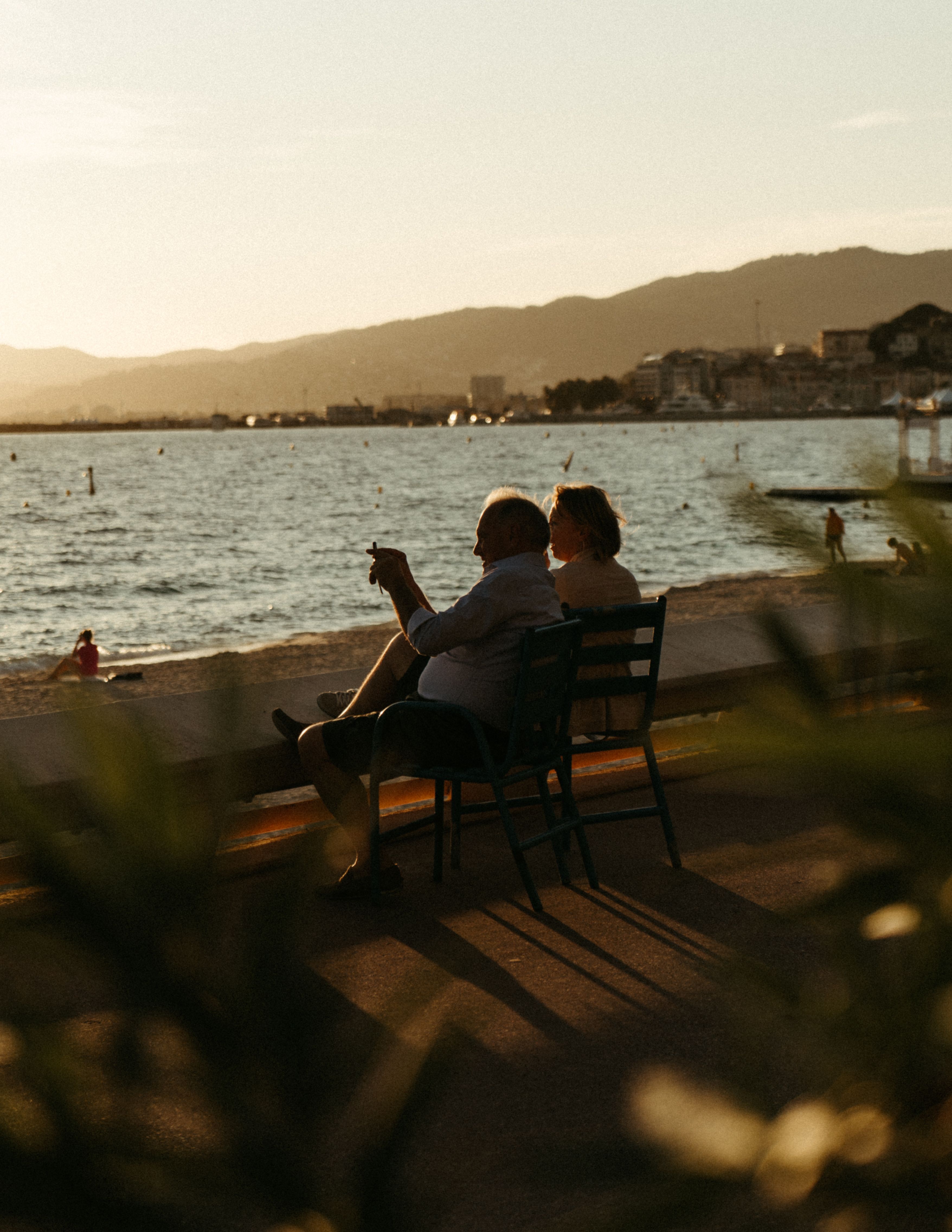 Couple Sitting on Brown Wooden Bench Near Body of Water · Free Stock Photo