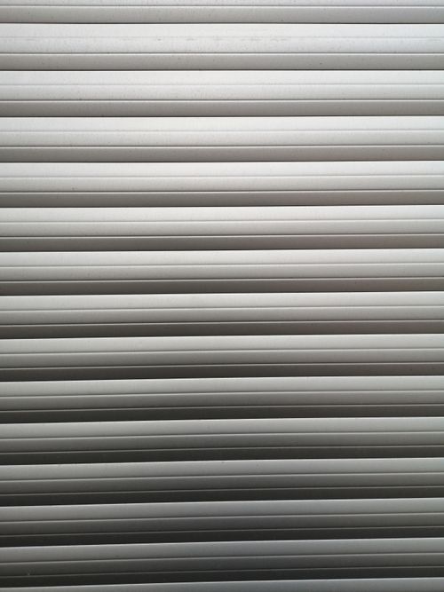 Free Close-up of a minimalist gray garage door with horizontal lines and soft lighting. Stock Photo