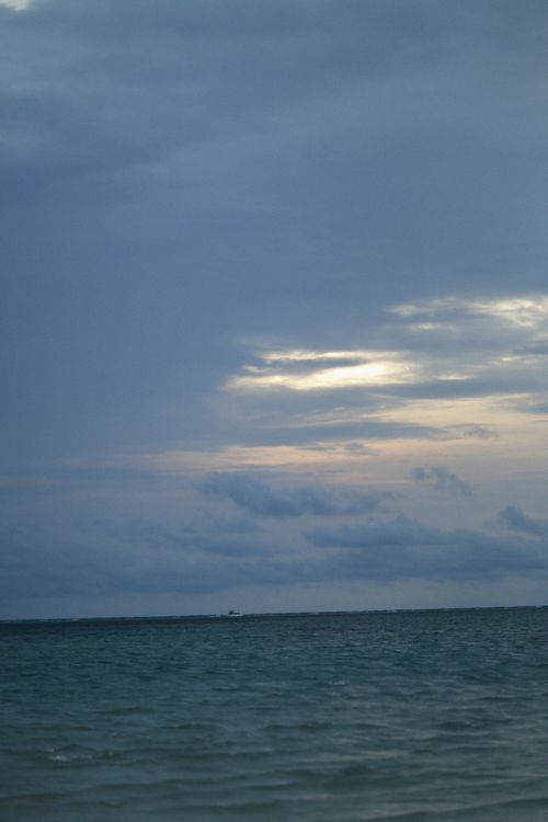 Free A peaceful seascape with overcast skies and a calm ocean during dusk. Stock Photo