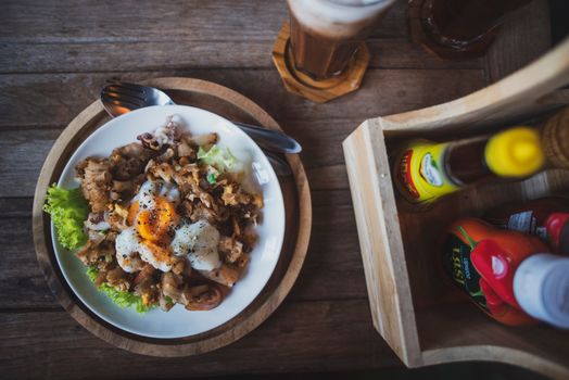 Top view of a delicious meal featuring a poached egg, lettuce, and condiments on a rustic table.