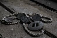 Close-up of vintage coins and rope on old wooden planks, evoking a sense of history and nostalgia.