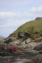 Person in Red Jacket Standing on Rocky Hill
