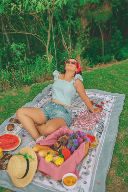 Adult Woman in Sunglasses Sitting on Picnic Blanket