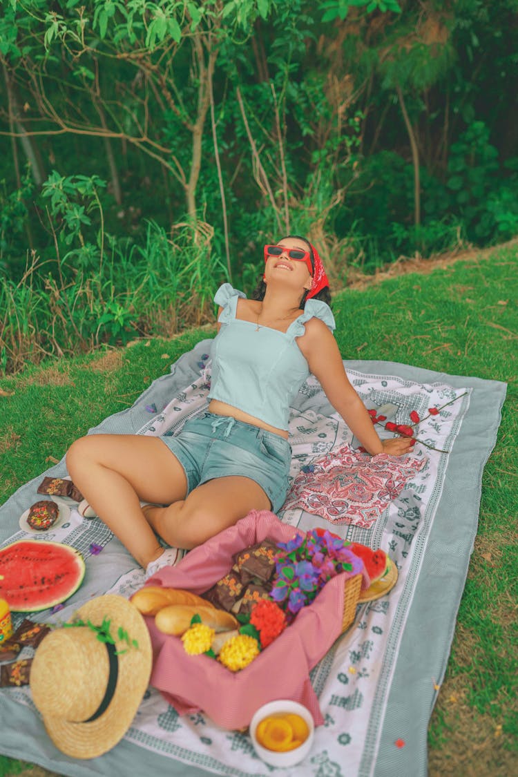 Adult Woman In Sunglasses Sitting On Picnic Blanket