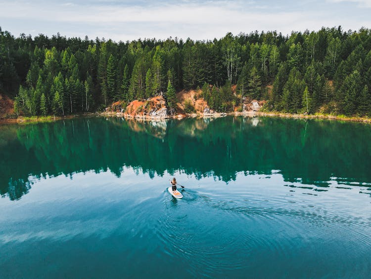 A Woman Doing Paddle Boarding On The Lake 