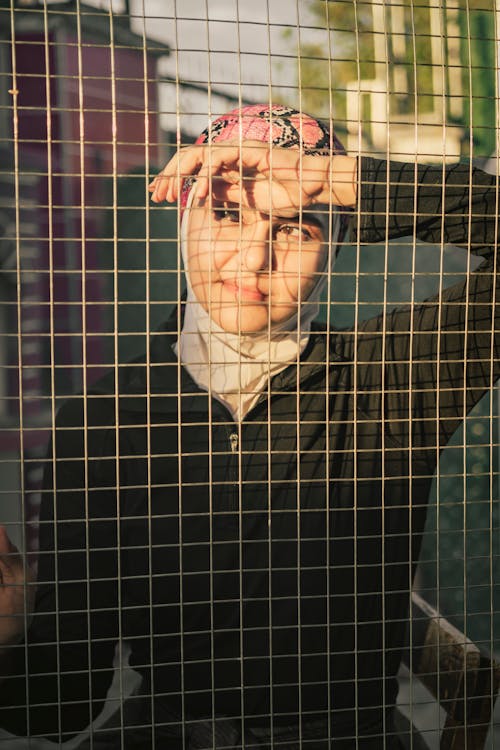 Free Pretty Woman in Hijab Behind the Fence Stock Photo