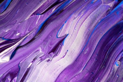 Free A close-up of vibrant violet and blue abstract paint swirls with a glossy texture. Stock Photo