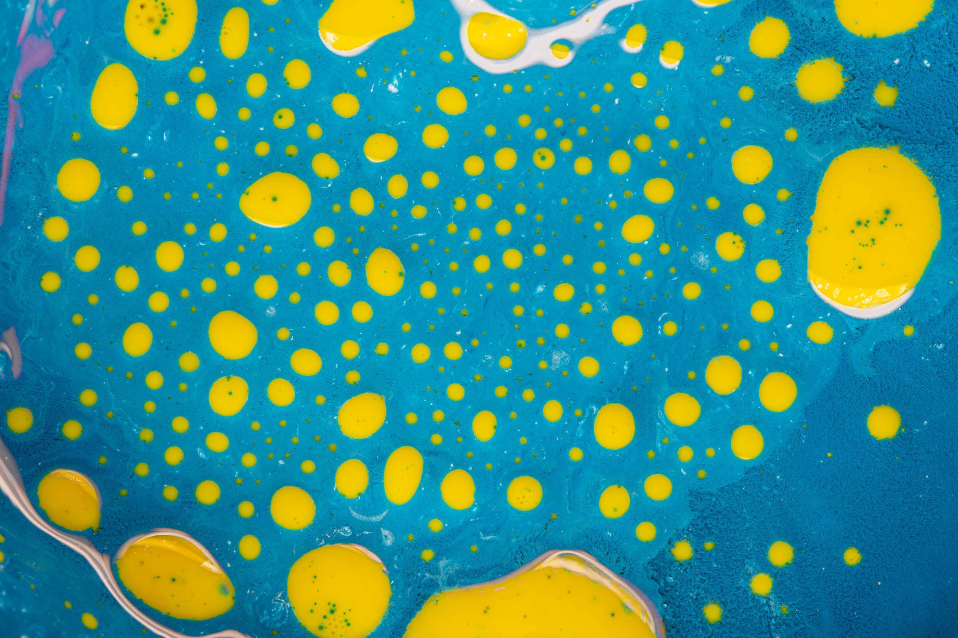 Dynamic abstract artwork with yellow spots on a vivid blue background.