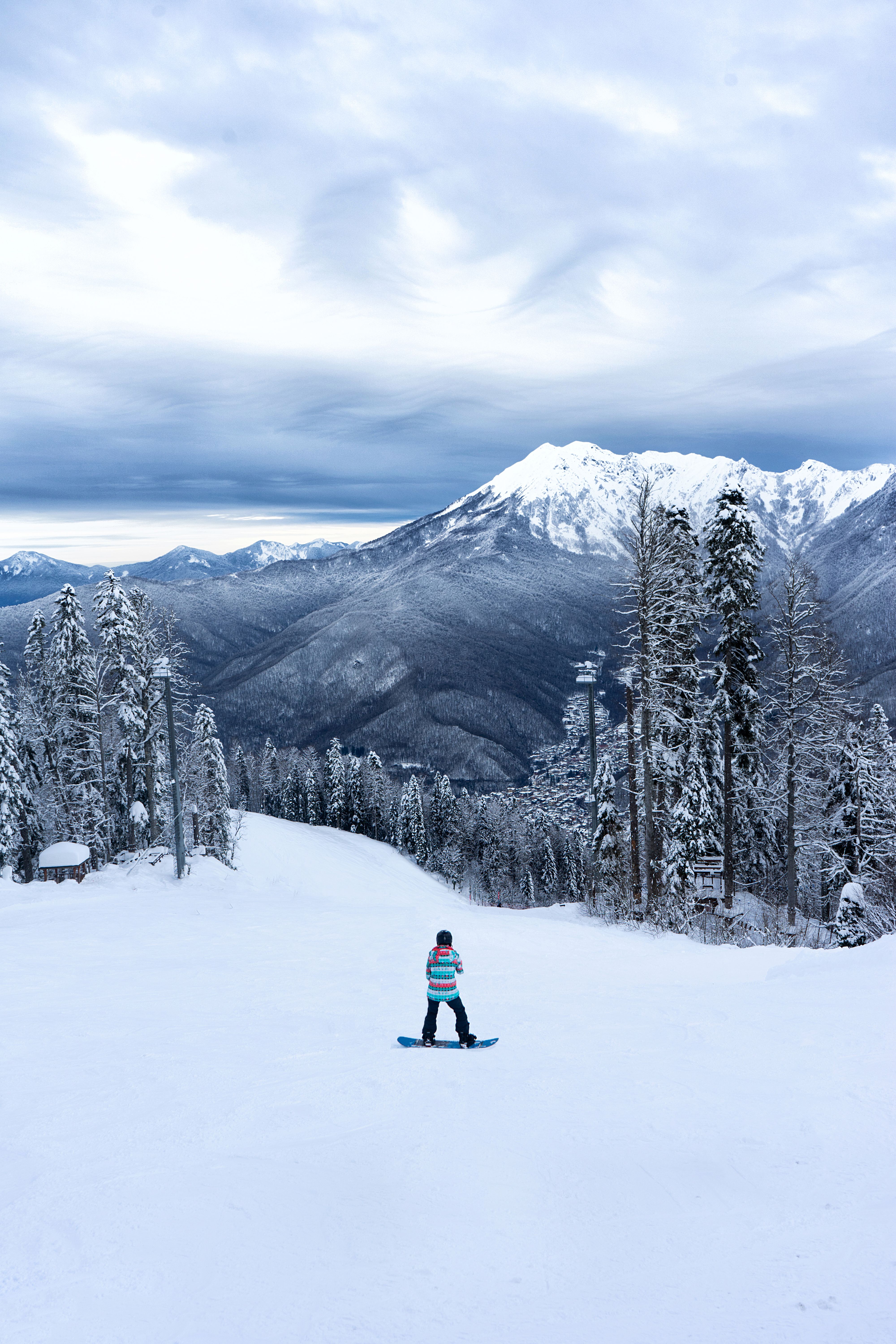 Lone snowboarder descending snowy mountains
