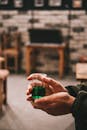 Person Holding Green Glass Bottle