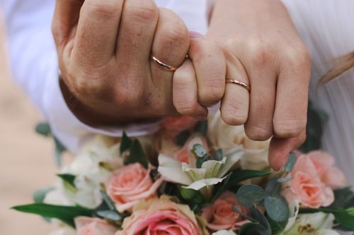 Free Intimate close-up of couple's hands with wedding rings, symbolizing love and commitment. Stock Photo