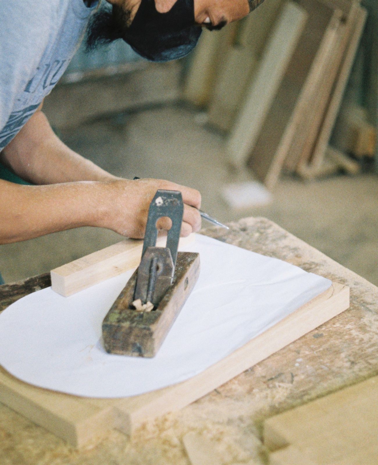 A carpenter planing wood by hand in a workshop