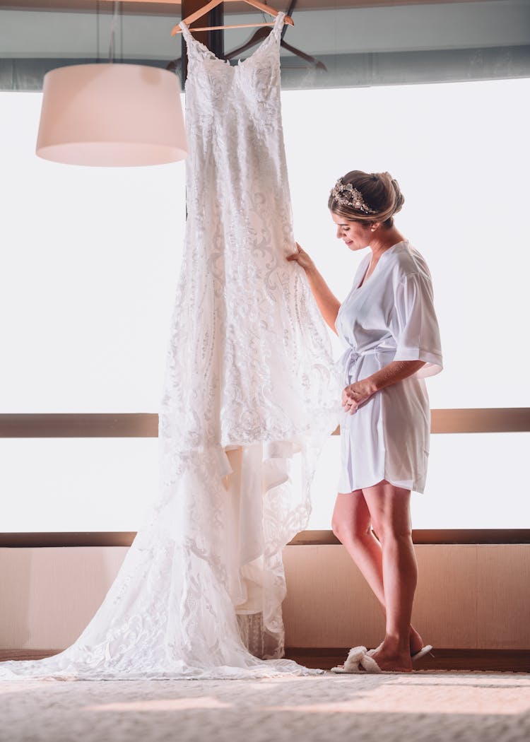 Woman Standing Near A Hanging Wedding Dress