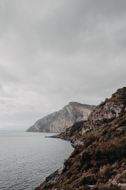 Free Serene coastal scene with rugged cliffs under an overcast sky, ideal for nature enthusiasts. Stock Photo
