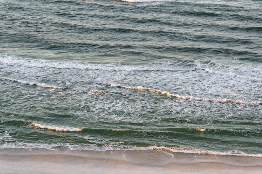 Captivating ocean waves gently crashing on Panama City Beach shoreline, capturing serene coastal beauty.