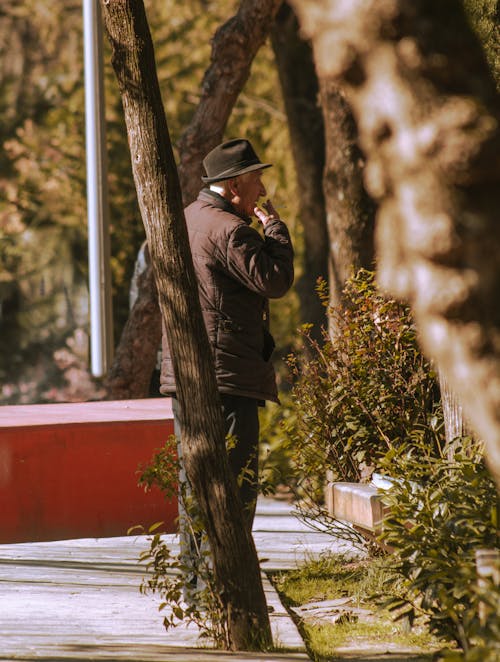 An Elderly Man Standing Near a Tree