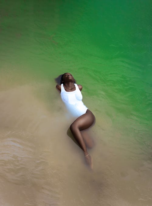 Free Woman in Swimming Costume Lying in Water Stock Photo