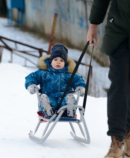 Photo of a Child Riding a Sled