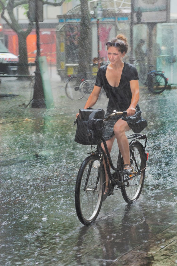 Woman Riding A Bicycle In The Rain