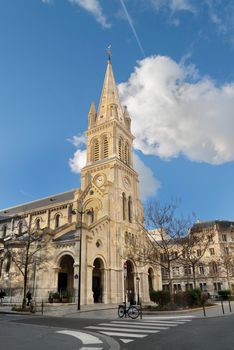 Stunning view of a Gothic Revival church in Paris against a bright blue sky.