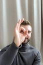 Man in Gray Sweater Covering His Face