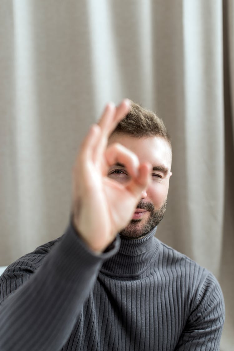 Photo Of A Man Looking Through The Hole In His Hand