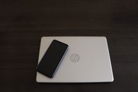 Close-Up Shot of a Smartphone on top of a HP Laptop