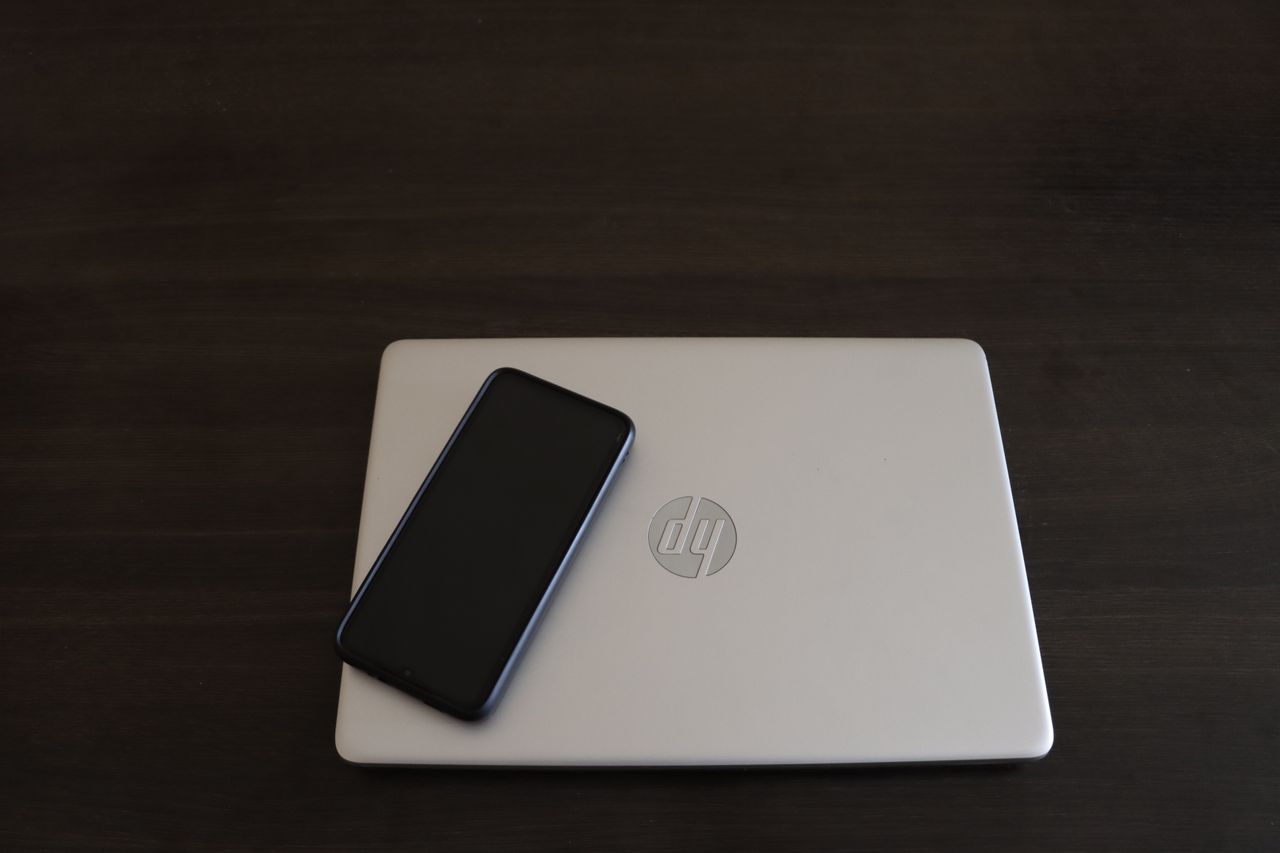 close up of a smartphone resting on an hp laptop symbolizing modern te