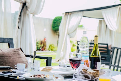 음식 접시, 와인 병, 머그잔이 가득한 테이블