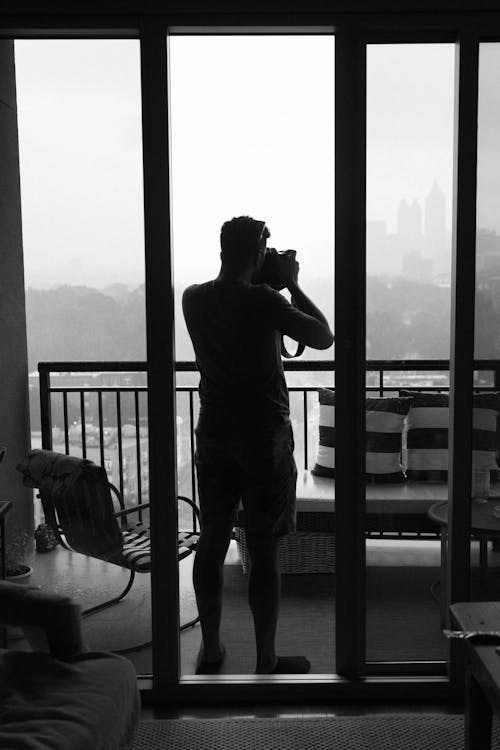 Free Silhouette of a Man Using a Camera Stock Photo