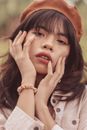 A Young Woman Posing with Hands on Her Face