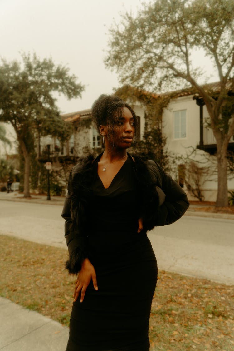 Woman In Black Dress Posing In Suburban Street