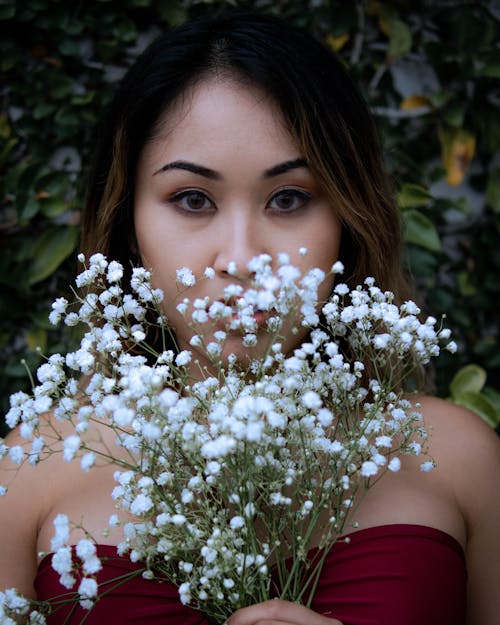 Close-Up Shot of a Woman Holding White Flowers