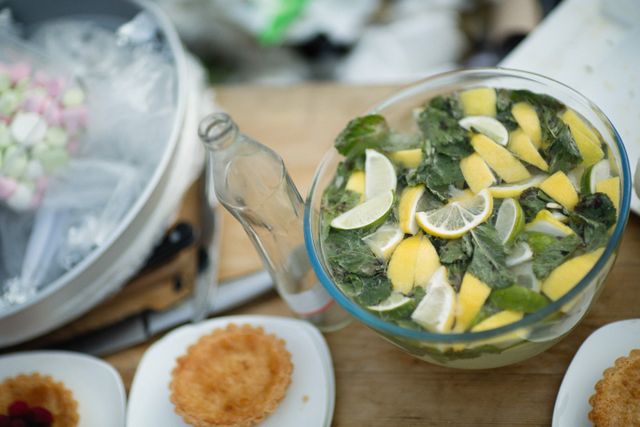 Lemon mint drink in glass bowl with pastries, perfect for summer refreshment.