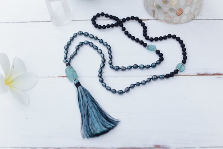 A Mala Beads Necklace On White Surface