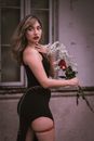 Woman Wearing Black Dress and Red Garter Belt Holding Bouquet