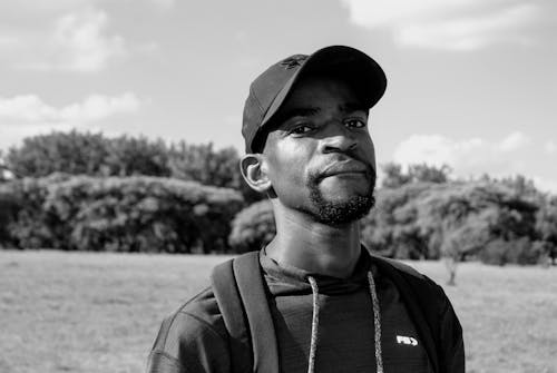 Free A Grayscale Photo of a Bearded Man Wearing a Cap Stock Photo