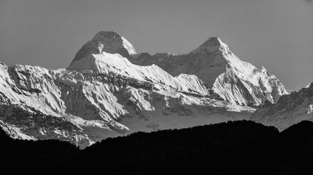 Black and white winter landscape of snow-capped Himalayas in Chaukori, India.