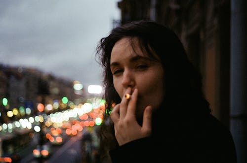Free A Woman in Black Shirt Smoking a Cigarette Stock Photo
