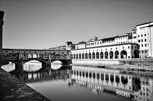 Free Grayscale image of the historic Ponte Vecchio and its reflection in Florence. Stock Photo