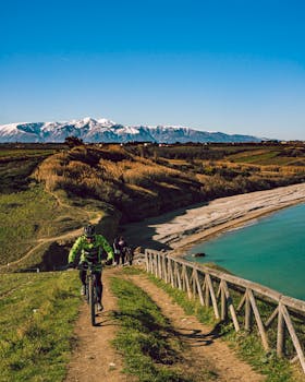 Cyclist exploring scenic landscapes in Abruzzo with mountains and seaside views.