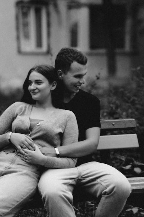 A Man and Woman Sitting on Bench