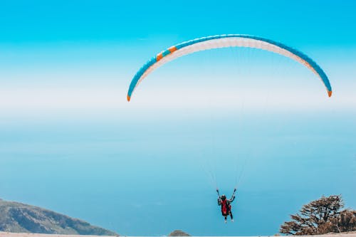 Free Person Paragliding in Blue Sky Stock Photo