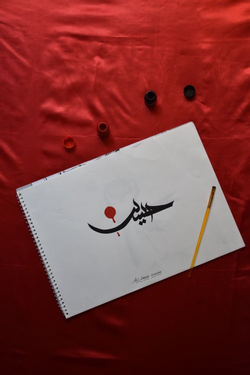 Free Close-up of a calligraphy artwork with a paintbrush on red fabric. Ideal for art and design themes. Stock Photo