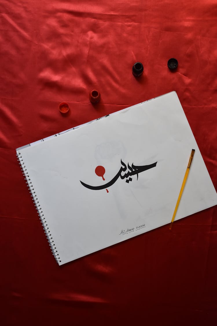 Persian Calligraphy And Tools On A Red Velvet Background