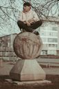 Woman in Black Long Sleeve Shirt and Black Pants Sitting on Brown Wooden Log