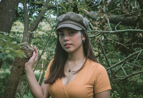 Free Close-up of a woman in a beret hat embracing nature, showcasing serene beauty. Stock Photo