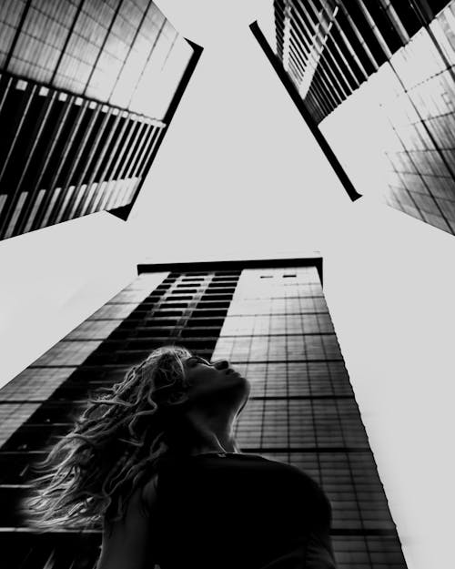 Woman Looking Up between three Towers